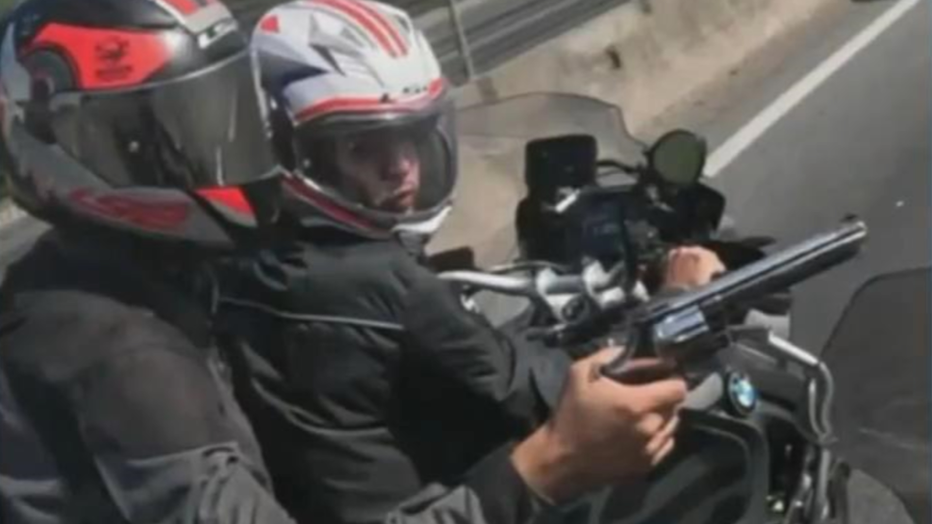 Dois homens estão na moto e um deles aponta a arma para o desembargador, que flagrou tudo com a câmera presa ao capacete
