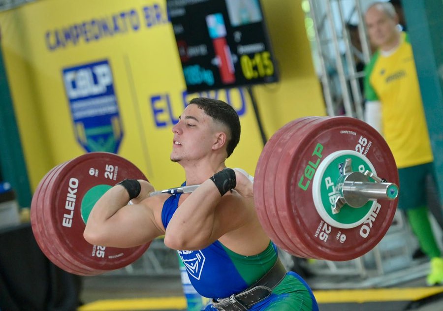 Foto mostra Matheus Pessanha levantando peso sobre os ombros